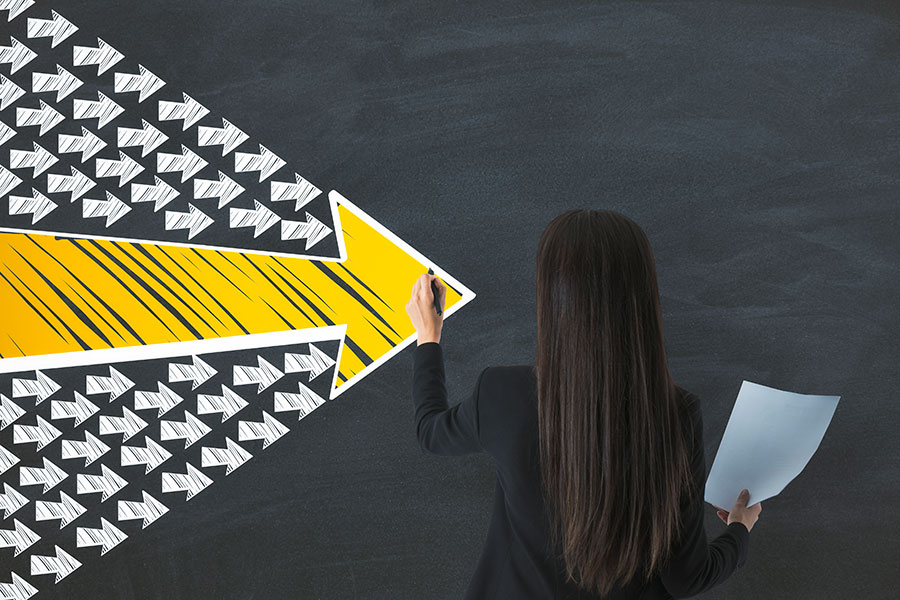 Mujer en pizarra dibujando flecha