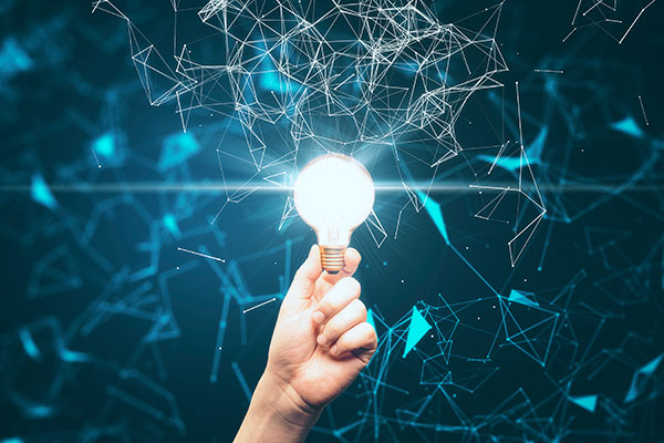 Mano sostiene bombilla brillante